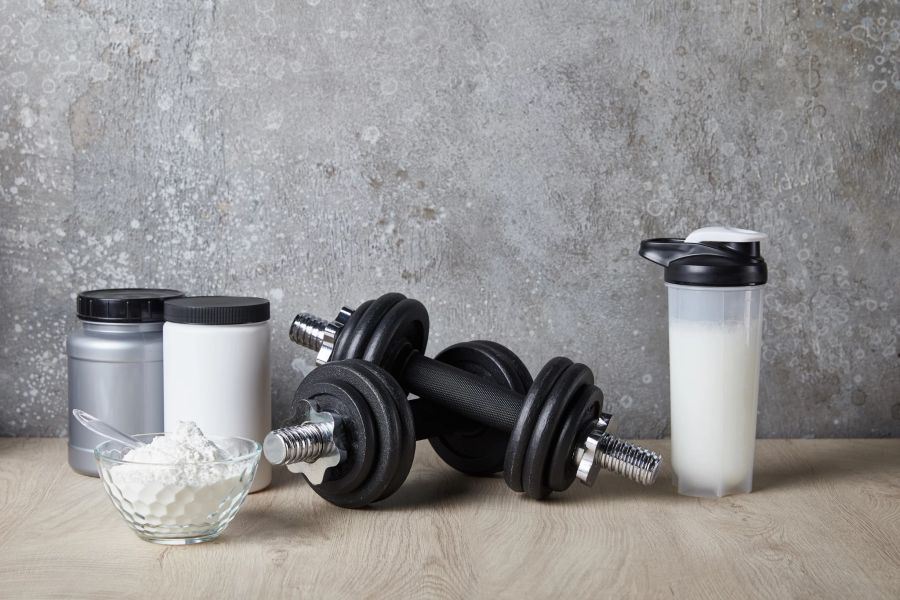 Proteinpulver und Shake mit Hanteln