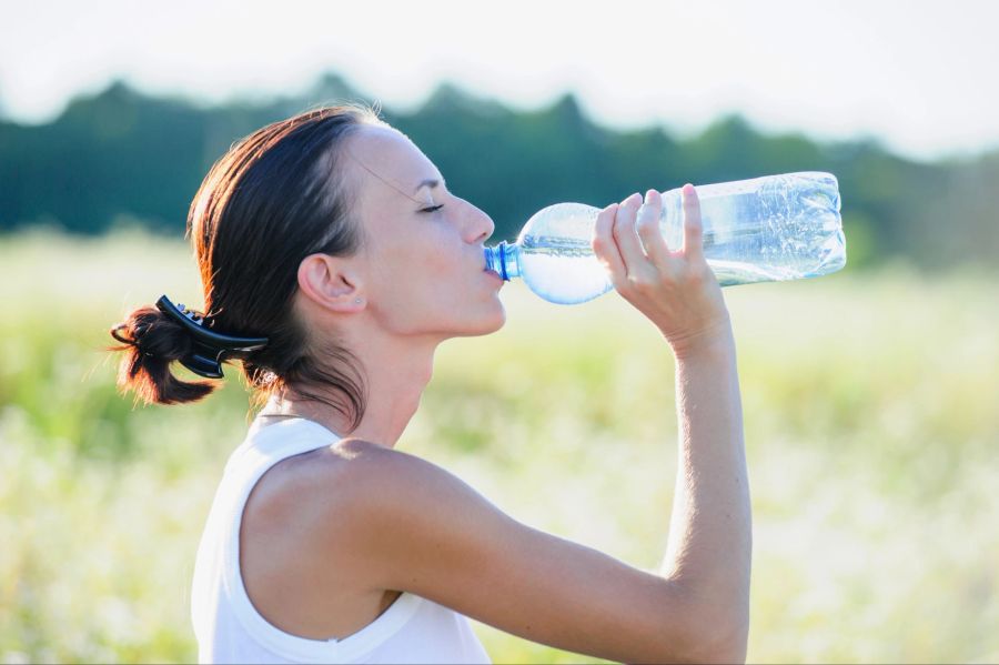 frau trinkt wasser, grüner hintergrund