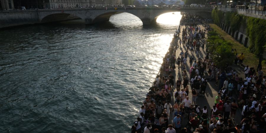 dpatopbilder - Menschen spazieren an der Seine entlang. Foto: Michel Euler/AP/dpa