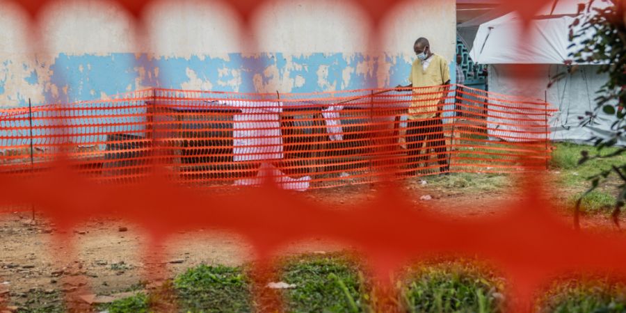 ARCHIV - Ein Mitarbeiter des Gesundheitswesens bereitet ein Ebola-Behandlungszentrum vor. Foto: Moses Sawasawa/AP/dpa/Archivbild