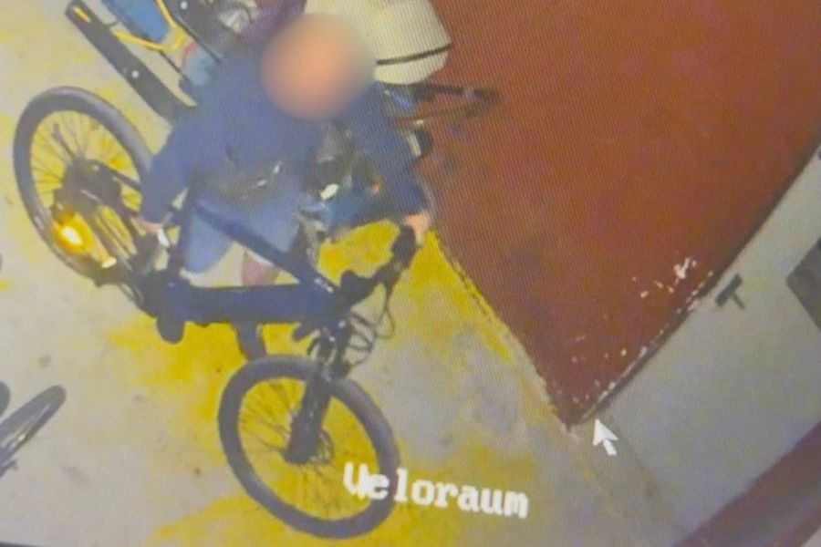 ... und rollt das Velo aus dem Raum.