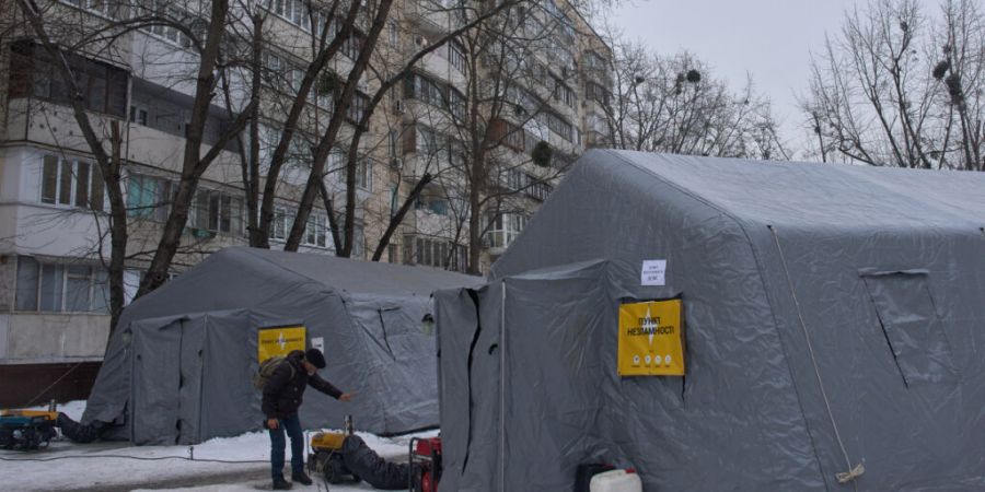 ARCHIV - Ein Mann wärmt sich in einem Zelt auf, in denen sich die Menschen aufwärmen können, nach den russischen Luftangriffen auf den ukrainischen Energiesektor. Ein Teil der Bewohn...