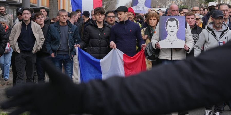Menschen nehmen an einem Marsch mit französischen Nationalflaggen und Porträts des getöteten Studenten Quentin teil. Der 23-Jährige war vor einer Woche am Rande einer Veranstaltung ...