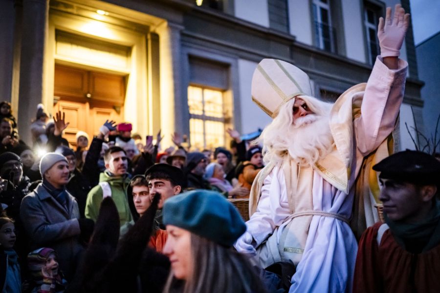 Auf seinem Esel winkt er der Menschenmenge zu.