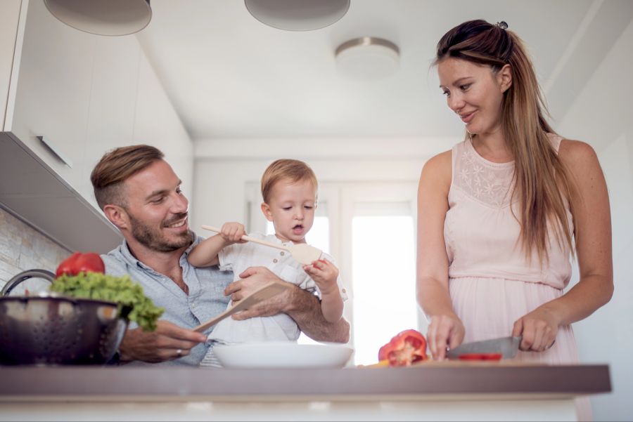 Eltern und Kind bereiten Salat zu