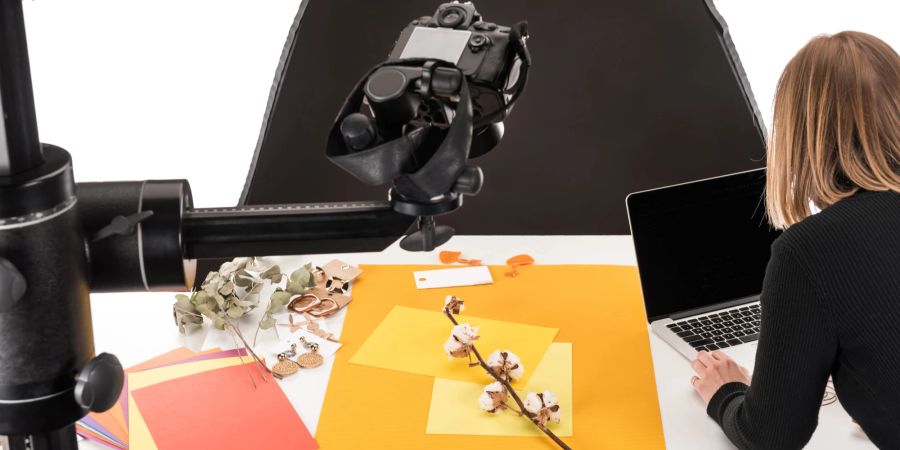 Frau fotografiert Schmuck im Studio