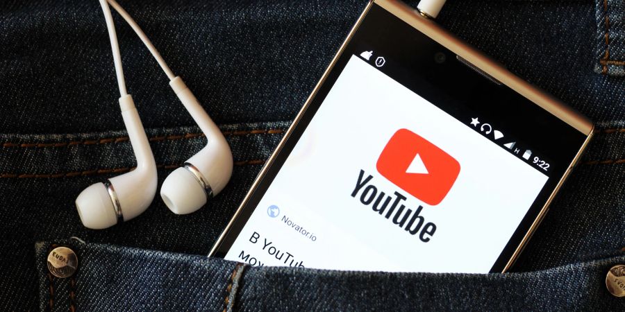 Smartphone in einer Hosentasche, YouTube App, Kopfhörer