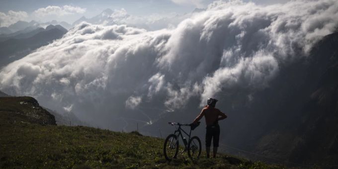 Eine Radfahrerin auf dem Grimselpass. Wetter Berge