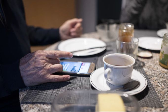 Senior nutzt Handy zum Kaffee