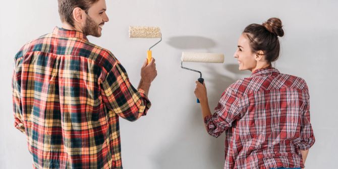 Mann und Frau streichen glücklich die Wand