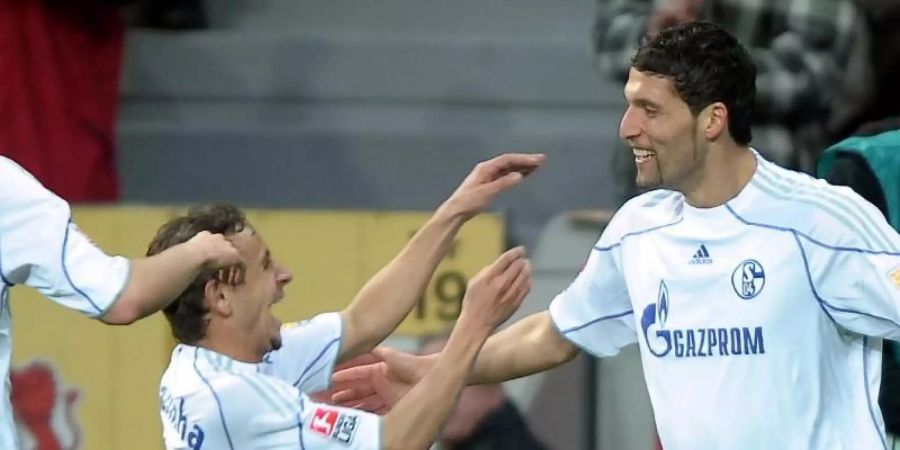 Spielten noch zu erfolgreicheren Zeiten gemeinsam auf Schalke: Rafinha (M) jubeln mit Kevin Kuranyi (r). Foto: picture alliance / dpa