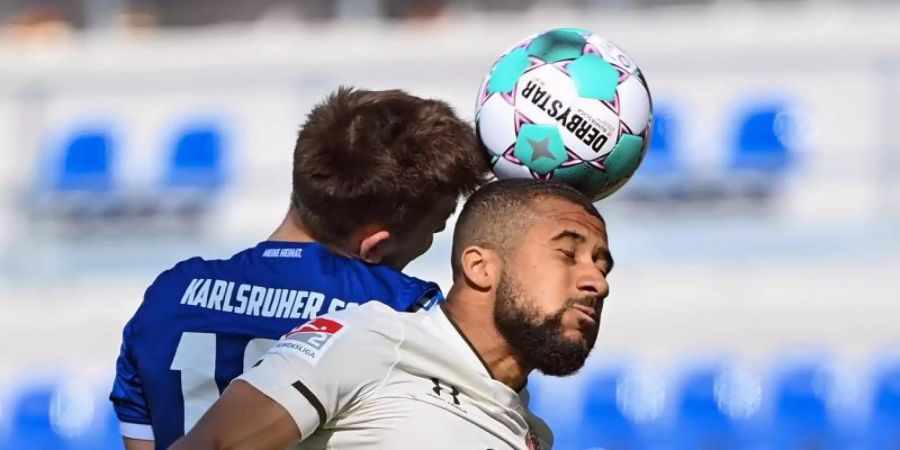 KSC-Profi Marvin Wanitzek (l) im Kopfballduell mit Daniel-Kofi Kyereh vom FC St. Pauli. Foto: Uli Deck/dpa