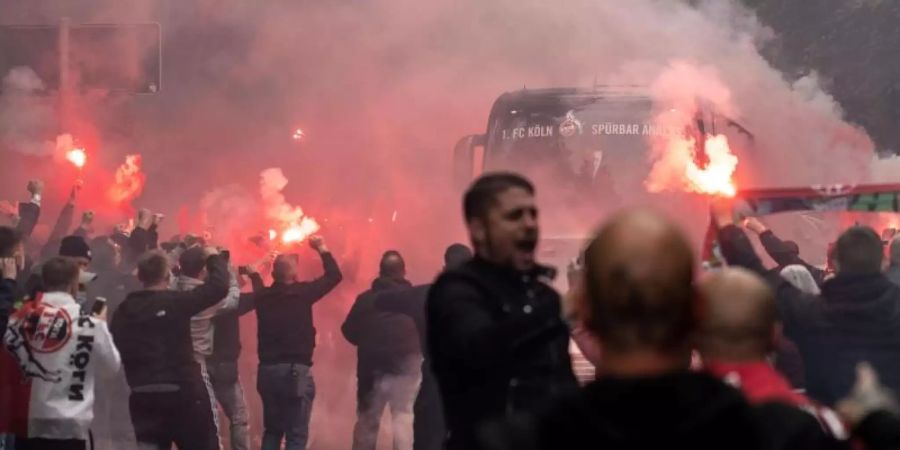 Der Mannschaftsbus des 1. FC Köln wird von den Fans mit Pyrotechnik am Stadion begrüsst. Foto: Marius Becker/dpa