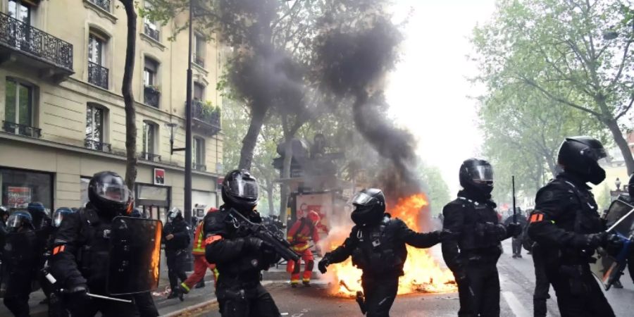 Polizisten vor brennenden Müllcontainern in Paris