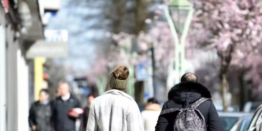 Menschen spazieren in Essen und geniessen das sonnige Wetter. Foto: Caroline Seidel/dpa