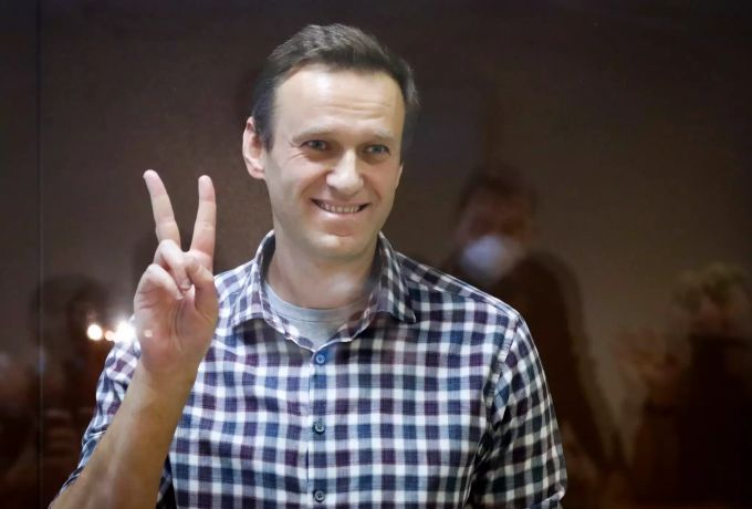 Oppositionsführer Alexej Nawalny steht in einem Käfig im Babuskinsky Bezirksgericht und zeigt das Peace-Zeichen. alexei anatoljewitsch nawalny
