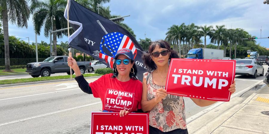 Zwei Trump-Anhängerinnen empfangen Ex-Präsident Donald Trump vor seinem Hotel in Miami mit Schildern, auf denen «Ich stehe hinter Trump» geschrieben steht.