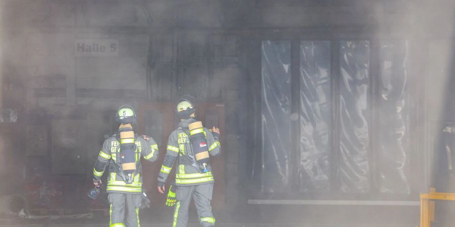 Kräfte der Feuerwehr verschaffen sich nach der Explosion in einer Industriehalle einen Überblick.