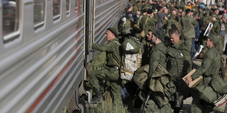 Russische Rekruten steigen im Rahmen der Teilmobilmachung im Ukraine-Krieg auf einem Bahnhof im russischen Prudbo in einen Zug.