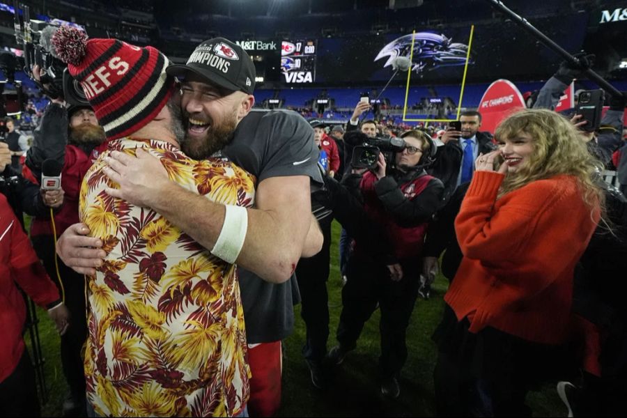 Der NFP-Footballer Jason Kelce (links) umarmt seinen Bruder, Kansas City Chiefs Tight End Travis Kelce, während Taylor Swift (rechts) zuschaut, nach dem AFC-Meisterschaftsspiel gegen die Baltimore Ravens, am 28. Januar 2024.