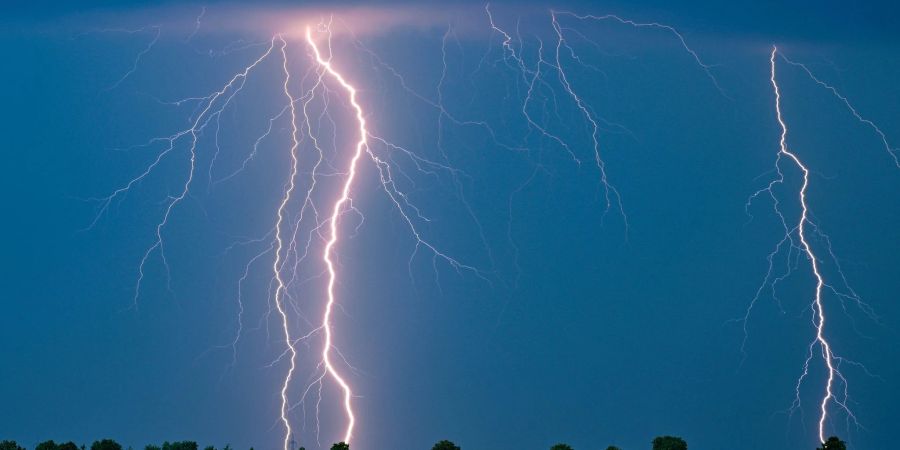 Blitze eines Gewitters leuchten am Abendhimmel im Osten des Landes Brandenburg.
