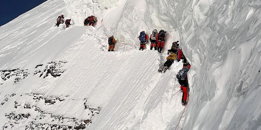 Nach seinem Absturz am K2 liegt der pakistanische Träger Mohammad Hassan (gelb) im Schnee. Zum Zeitpunkt dieser Aufnahme lebte er noch.