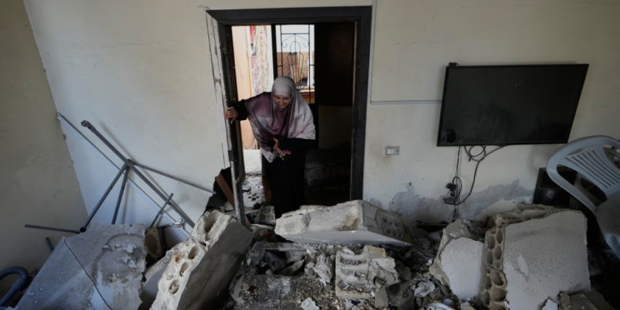 dpatopbilder - Eine Frau betritt ihr Haus, das bei einem israelischen Luftangriff im Dorf Burj al-Shemali in der Nähe der südlichen Hafenstadt Tyrus zerstört wurde. Foto: Mohammed Za...
