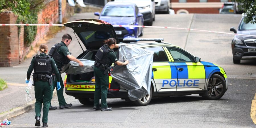 Angehörige der nordirischen Polizei sichern den Bereich um den Tatort einer Messerstecherei. Foto: Peter Morrison/AP/dpa