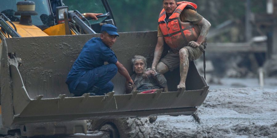 Rettungskräfte setzen am Trishuli-Fluss im nepalesischen Distrikt Nuwakot einen Radlader ein, um ein Opfer einer Sturzflut in Sicherheit zu bringen. Foto: Niranjan Shrestha/AP/dpa