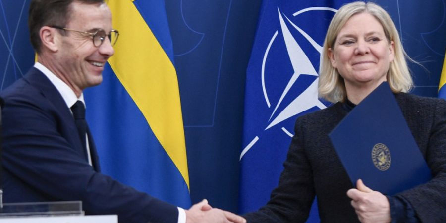 ARCHIV - Schwedens Ministerpräsident Ulf Kristersson (l) und seine Vorgängerin Magdalena Andersson geben sich die Hand. Foto: Lars Schröder/TT/TT News Agency/AP/dpa