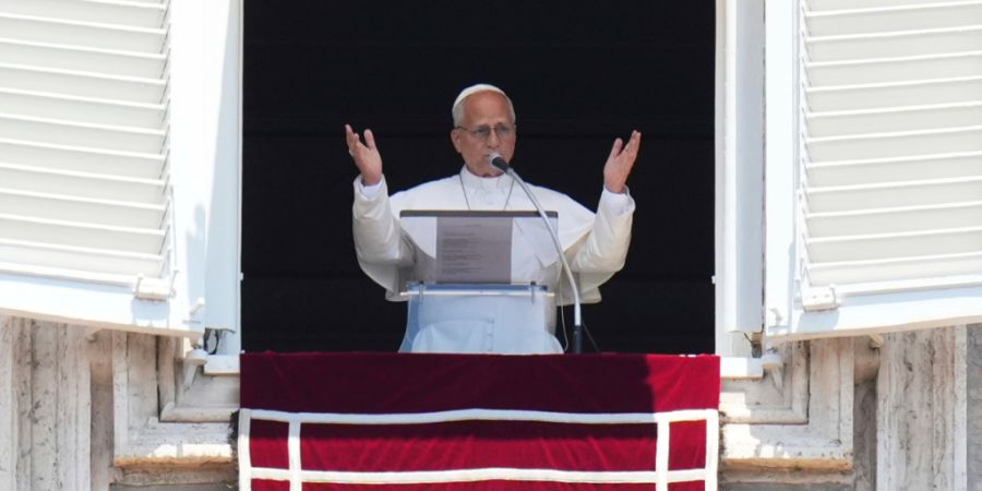 Papst Leo XIV. steht am Fenster seines Arbeitszimmers mit Blick auf den Petersplatz im Vatikan. Foto: Alessandra Tarantino/AP/dpa
