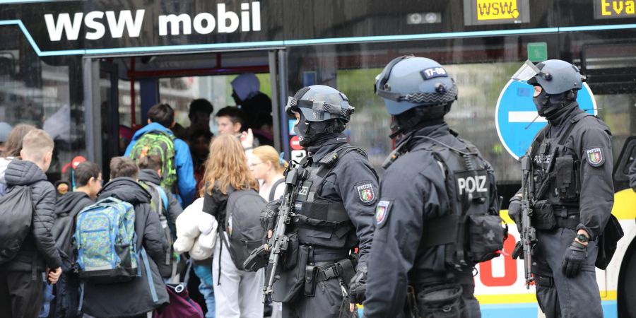 Polizisten führen Schüler in Wuppertal aus dem Gebäude in einen Evakuierungsbus.