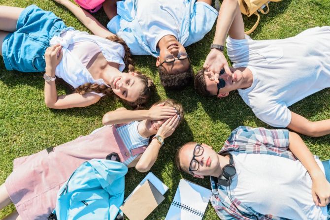 Teenager liegen im Gras