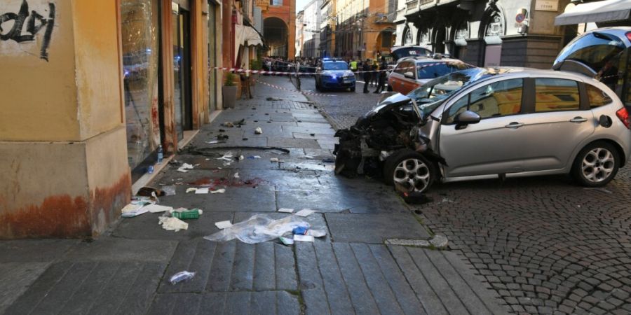 dpatopbilder - Ein schwer beschädigtes Auton steht nach einem Unfall in einer Straße in Modena. Ein Mann war mit dem Auto in eine Menschenmenge gefahren. Acht Menschen seien verletzt ...