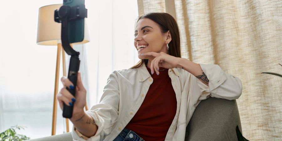 Frau mit Smartphone und Selfie-Stick