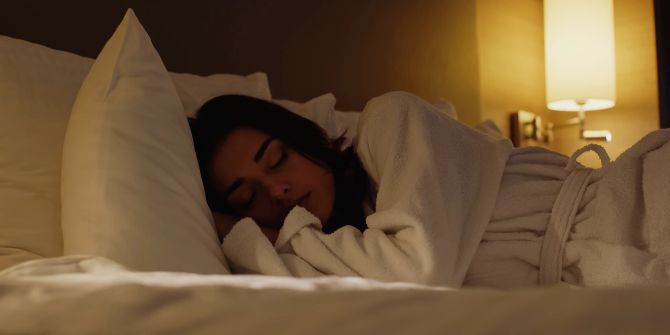Frau schläft im Hotelbett.