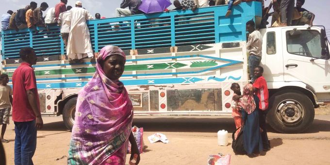 Menschen besteigen einen Lastwagen, um eine Stadt im Sudan zu verlassen. Sudan