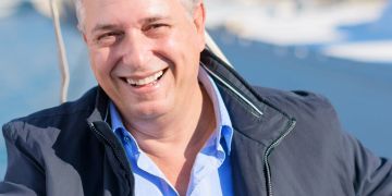 älterer mann auf segelboot, lächelnd