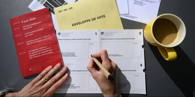 Eine Person füllt die Abstimmungszettel aus für die Volksabstimmung vom 9. Juni 2024. Volksabstimmung 9. Juni 2024