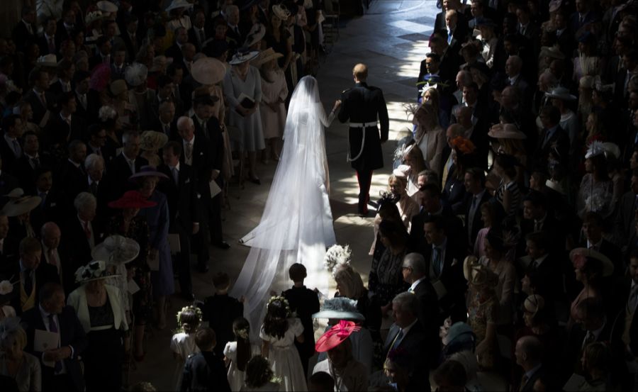 Harry und Meghan schreiten durch den Saal – von etwaigen Familienspannungen bekommen die Gäste nichts mit. (Archivbild)