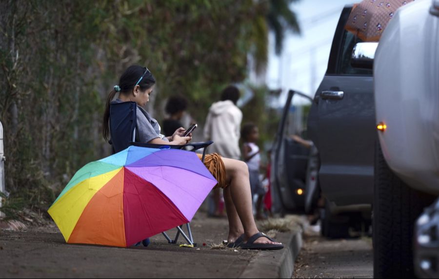 Hier warten Personen am Strassenrand aufgrund der Evakuierungen wegen der Tsunami-Warnung in Hawaii.