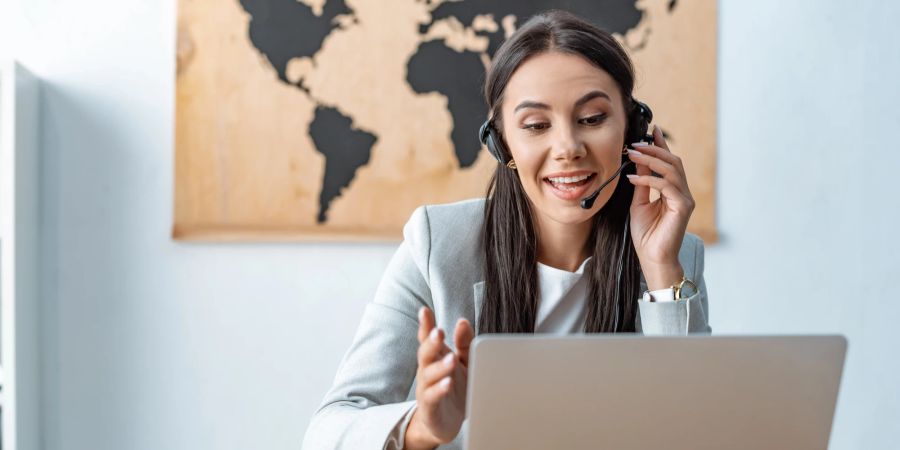 Reisebüro, Frau mit Headset am Laptop