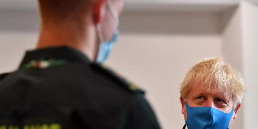 Premier Boris Johnson spricht während eines Besuchs im Hauptquartier des London Ambulance Service NHS Trust mit einem Sanitäter. Foto: Ben Stansall/PA Wire/dpa