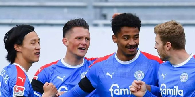 Kiels Emmanuel Iyoha (2.v.r.) bejubelt sein Führungstor mit Alexander Mühling (r), Fabian Reese (2.v.l.) und Jae-sung Lee. VfB Stuttgart