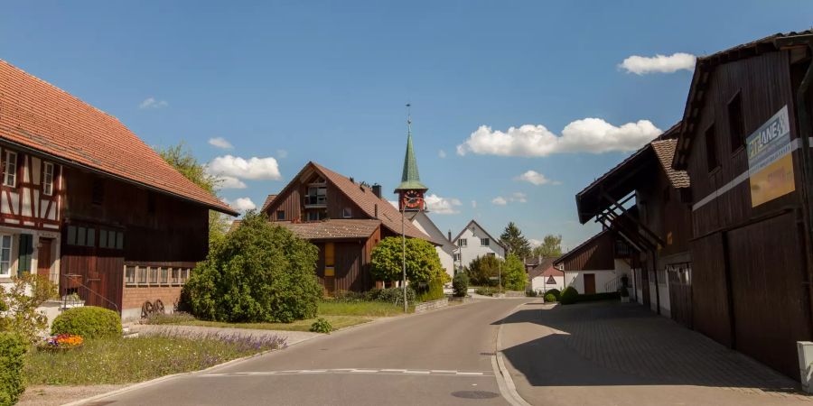 Die Dorfstrasse in Dietlikon, im Hintergrund die reformierte Kirche.