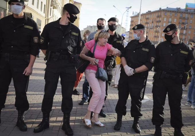 Eine Frau diskutiert mit Polizisten in Belarus. Belarus