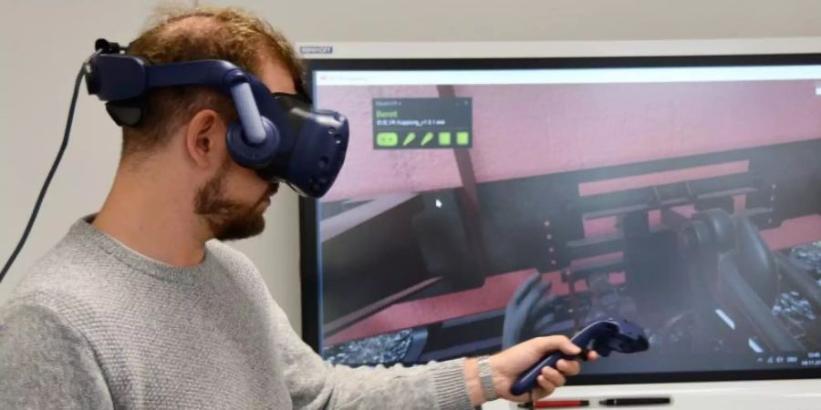 Im Trainingszentrum der Deutschen Bahn können Auszubildende mit einer VR-Brille üben, Güterwaggons aneinanderzukoppeln. Foto: Jörn Perske/dpa