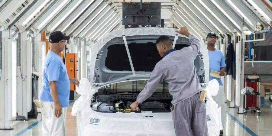 Mitarbeiter des Fahrzeugherstellers VW montieren im Werk Uitenhage in Südafrika einen Pkw. Der Konzern plant gemeinsam mit anderen Unternehmen über «Leuchtturm-Projekte» in Ländern wie Ruanda, Ghana, Kenia und anderen eine verzahnte Automobilindustrie für den Kontinent aufzubauen. Foto: Michael Sheehan/dpa