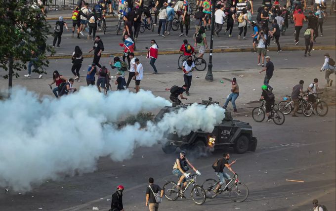 Ein gepanzertes Polizeifahrzeug setzt Tränengas während eines Protests gegen Demonstranten ein. Proteste in Chile
