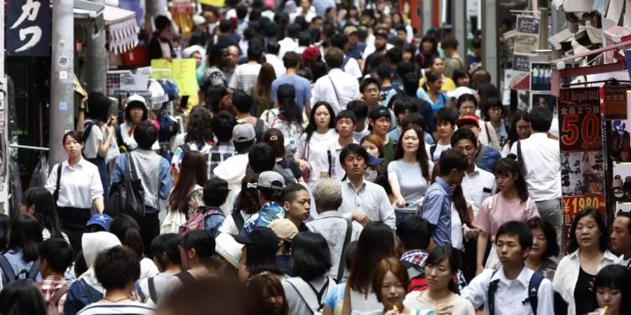 Menschen drängen sich auf einer Strasse der Stadt. Foto: Yuya Shino/epa/dpa